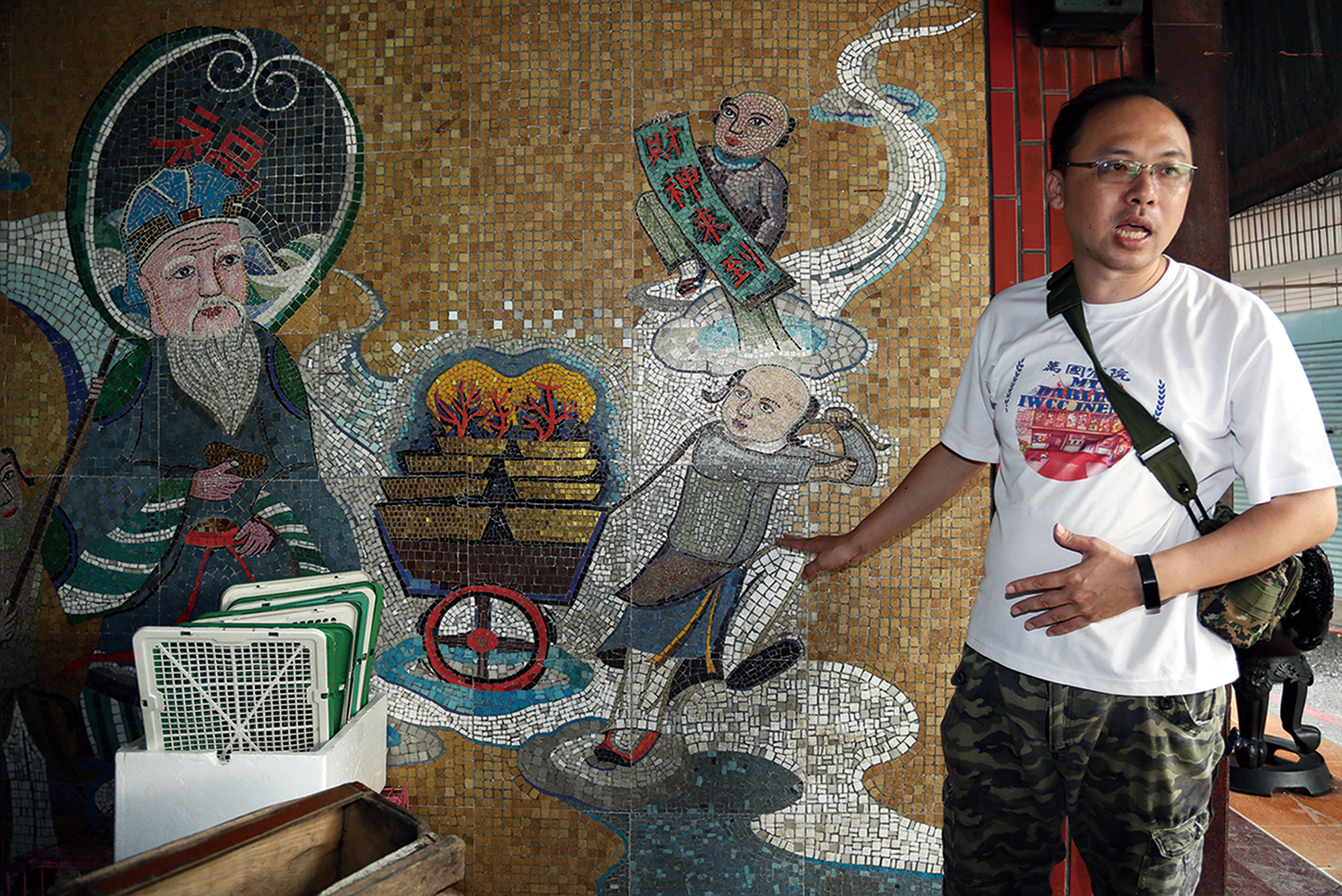 江明赫每月定期舉辦「大林小旅行」， 帶訪客了解老巷弄、新店家的故事，圖為他解說在地藝術家簡源忠以西方馬賽克拼貼的土地公壁畫。